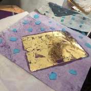 3: The gold foil is placed on the adhesive and heat set
